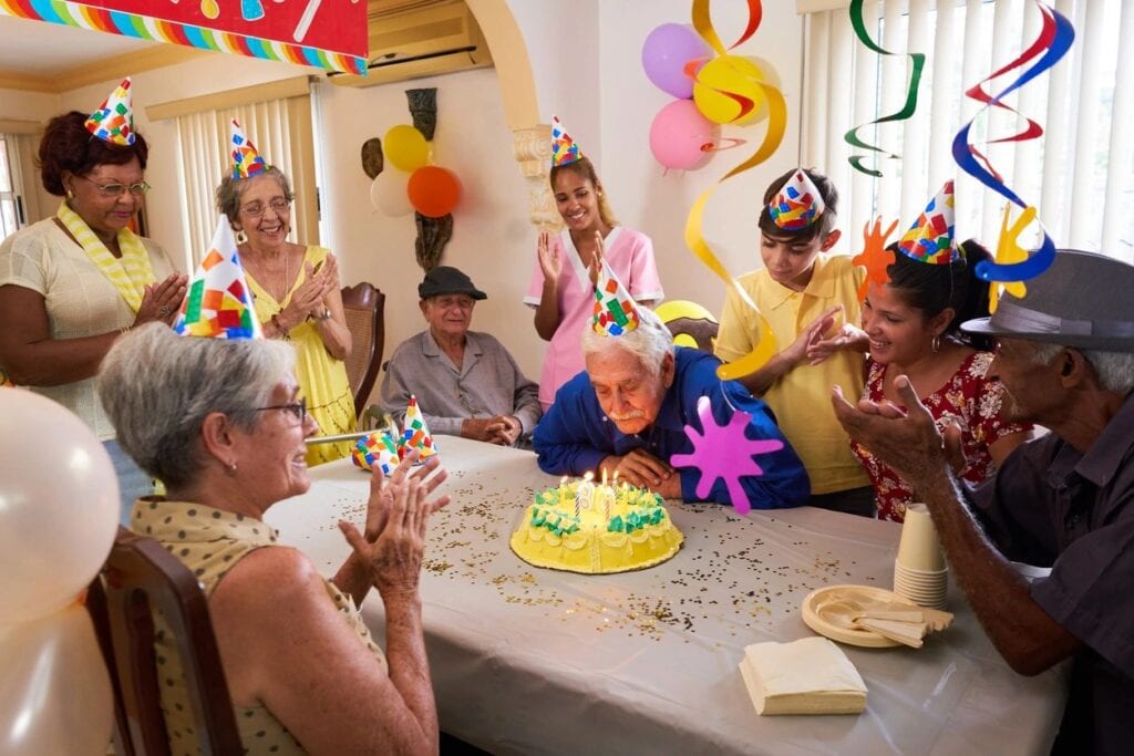 An elderly man celebrating his birthday with his senior friends